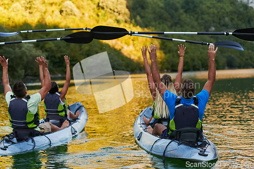 Image of A group of friends enjoying having fun and kayaking while exploring the calm river, surrounding forest and large natural river canyons