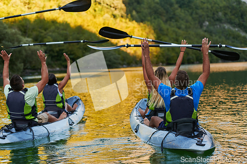 Image of A group of friends enjoying having fun and kayaking while exploring the calm river, surrounding forest and large natural river canyons