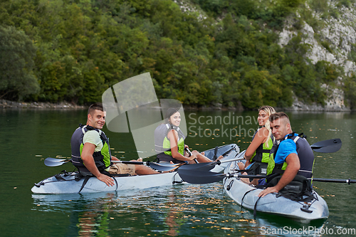 Image of A group of friends enjoying having fun and kayaking while exploring the calm river, surrounding forest and large natural river canyons