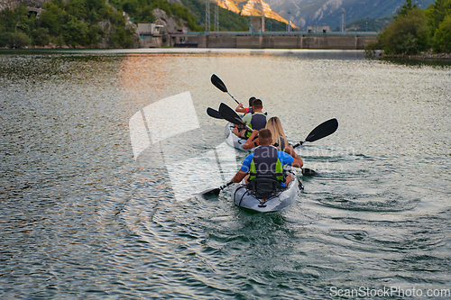 Image of A group of friends enjoying having fun and kayaking while exploring the calm river, surrounding forest and large natural river canyons