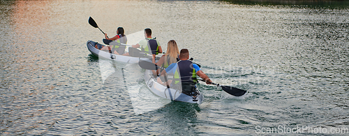 Image of A group of friends enjoying having fun and kayaking while exploring the calm river, surrounding forest and large natural river canyons