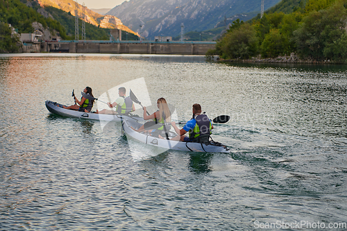 Image of A group of friends enjoying having fun and kayaking while exploring the calm river, surrounding forest and large natural river canyons