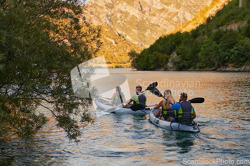 Image of A group of friends enjoying having fun and kayaking while exploring the calm river, surrounding forest and large natural river canyons