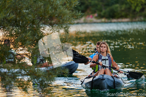 Image of A group of friends enjoying having fun and kayaking while exploring the calm river, surrounding forest and large natural river canyons