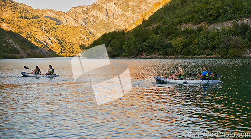 Image of A group of friends enjoying having fun and kayaking while exploring the calm river, surrounding forest and large natural river canyons