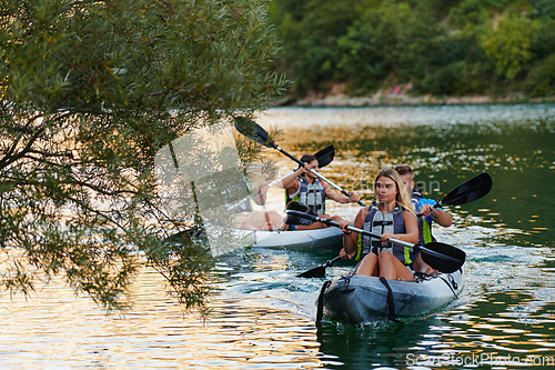 Image of A group of friends enjoying having fun and kayaking while exploring the calm river, surrounding forest and large natural river canyons