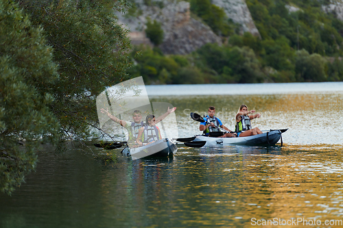 Image of A group of friends enjoying having fun and kayaking while exploring the calm river, surrounding forest and large natural river canyons