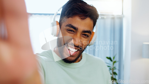 Image of Selfie, man and smiling with headphones for music playlist streaming and cheerful mood in home. Wellness laughing, audio and happy male ready to dance photograph with smile.