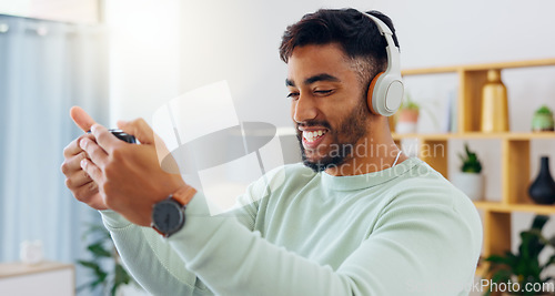 Image of Indian man with smartphone, headphones and face, music and smile, scroll social media and audio streaming. Online, listening to radio or podcast with happiness and relax with texting or email