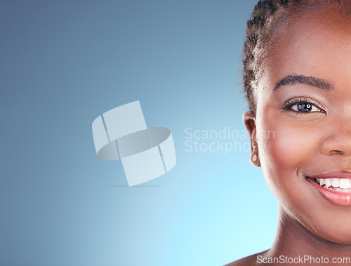 Image of Portrait of black woman with mockup space for skincare, beauty and smile on blue background. Spa aesthetic, dermatology and half face of person in studio with cosmetics, makeup and glow for wellness