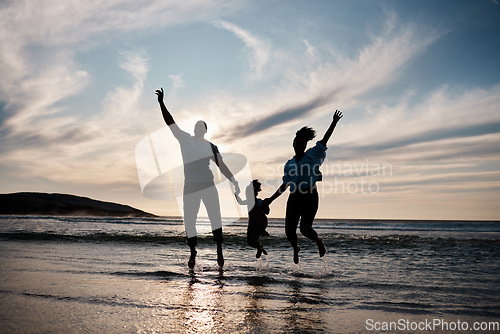 Image of Family, jump and freedom on beach with silhouette, fun together outdoor with games and bonding on vacation. Travel, adventure and playful, parents and child with happy people in air and energy