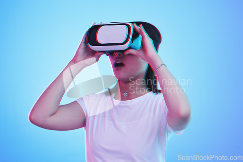 Image of Woman, VR and glasses with wow in futuristic experience, 3d games and gen z education or digital e learning. Young person or student in virtual reality, high tech and vision on blue studio background