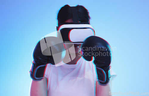 Image of AI, metaverse and a boxer woman gaming on a blue background in studio for fitness or exercise. Virtual reality, sports and training with a young female player boxing an online fantasy game for health