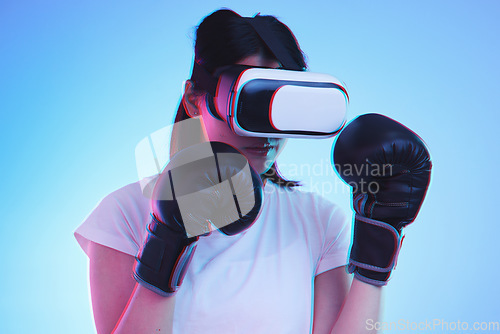 Image of AI, metaverse and a sports woman boxing on a blue background in studio for fitness or exercise. Virtual reality, gamer and training with a young female boxer playing an online fantasy game for health