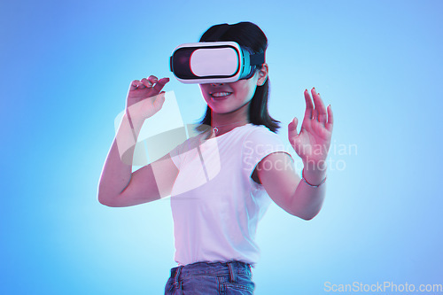 Image of Metaverse gaming, headset and woman on blue background for virtual reality creativity. Smile, touching and a girl with digital glasses for a cyber game, experience or future technology on a backdrop