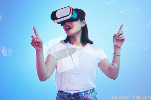 Image of Woman, virtual reality and glasses for futuristic gaming, metaverse and user experience with high technology. Happy person press bubbles in VR fantasy, 3d vision and scifi on blue, studio background