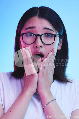 Image of Surprise, shocked and face of Asian woman with wow expression or open mouth for drama, deal and promotion. Omg, wtf and portrait of person with discount emoji isolated in a studio blue background
