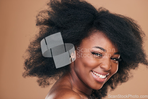 Image of Portrait, hair care and black woman with beauty, afro and smile on a brown studio background. Cosmetics, person and African model with texture, shine and volume with aesthetic, wellness and glow