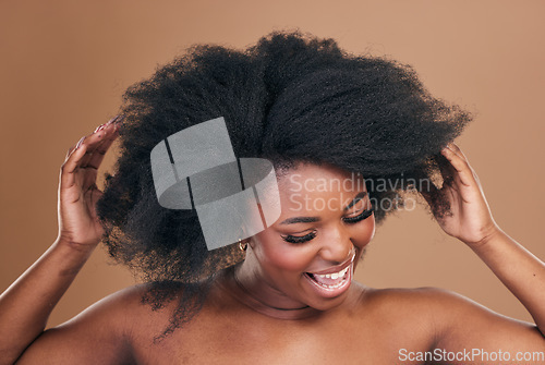 Image of Beauty, hair and crazy with a model black woman in studio on a brown background for natural cosmetics. Face, smile and haircare with a playful young afro female person indoor for shampoo treatment