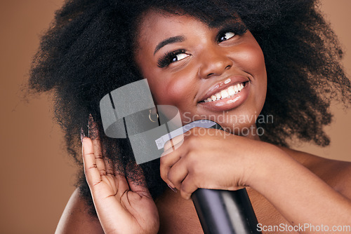 Image of Face, hair and spray with a black woman in studio on a brown background for natural cosmetics. Thinking, smile and haircare with a happy young afro model indoor for shampoo or keratin treatment