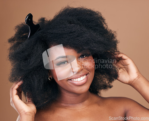 Image of Portrait, hair and comb for beauty with a black woman in studio on a brown background for natural cosmetics. Face, smile and haircare with a happy young afro female model indoor for shampoo treatment