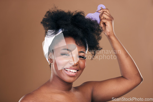 Image of Comb, hair care or portrait of black woman with afro, self love or smile on a brown studio background. Hairstyle, beauty or happy African model with natural shine or volume with aesthetic or wellness