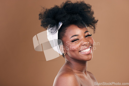 Image of Portrait, hair care or happy black woman with afro, self love or smile on a brown studio background. Hairstyle, beauty or African model with texture, shine and volume with aesthetic, wellness or glow