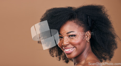 Image of Portrait, hair care and black woman with natural beauty, shine and smile on a brown studio background. Mockup space, person and model with texture, afro and volume with aesthetic, wellness and glow