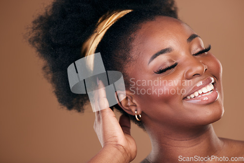 Image of Beauty, hair and smile with a model black woman in studio on a brown background for natural cosmetics. Face, makeup and haircare with a happy young afro female person indoor for shampoo treatment