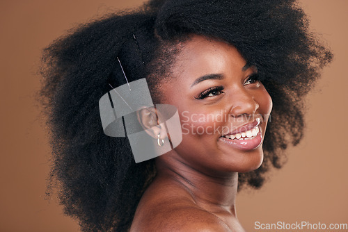 Image of Hair care, afro or face of happy black woman with self love, shine or smile on a brown studio background. Hairstyle, healthy growth or African model with glow, beauty or wellness thinking of skincare