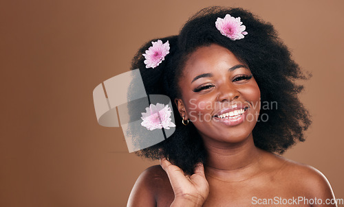Image of Afro hair, mockup or portrait of black woman with flowers, beauty or smile on a brown studio background. Hairstyle, space or happy African model with aesthetic, wellness or glow with floral plants