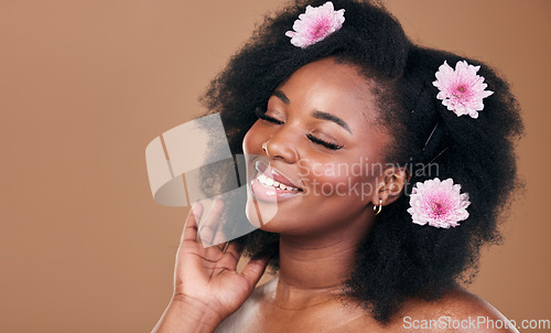 Image of Hair care, flowers and black woman in afro, smile and beauty in studio isolated on brown background mockup space. Floral plant, hairstyle cosmetic and natural African model in organic salon treatment