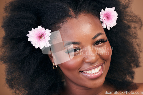 Image of Face, flowers and black woman in afro hair care, smile and beauty in studio isolated on a brown background. Portrait, floral hairstyle cosmetic and natural African model in organic salon treatment