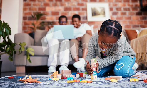 Image of Playing, house and a child with building blocks and parents on the sofa with a laptop and relax. Happy, black family and a girl kid with toys on the lounge floor for education, learning and a game