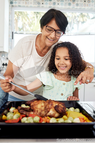 Image of Kitchen, health and a grandmother cooking with her grandchild in their home together for thanksgiving. Children, love and a roast with a senior woman preparing a meal with a girl for food nutrition