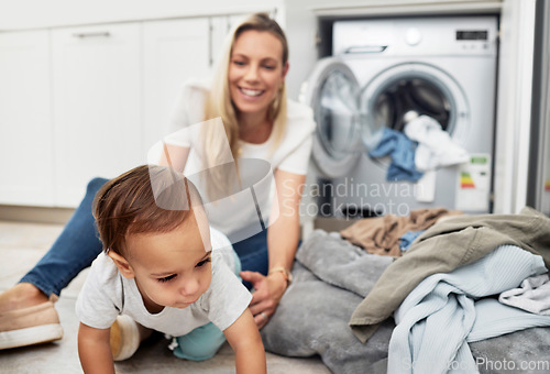 Image of Child, mother and laundry at home with family for housework, chores and clean clothes. A happy woman with a washing machine for cleaning and playing with toddler kid while multitasking as a mom