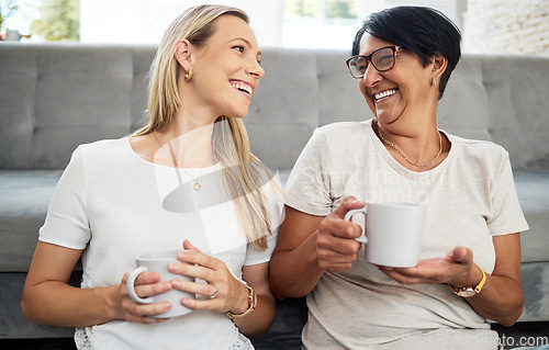 Image of Women friends, coffee and living room floor with smile, funny conversation and relax with care, diversity and love. Mature lady, happy and together with latte, espresso and comic laugh in home lounge