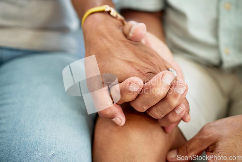 Image of Love, support and couple holding hands for bonding, unity and connection in the living room of their home. Empathy, closeup and people with affection moment for sympathy after loss, sadness or grief.