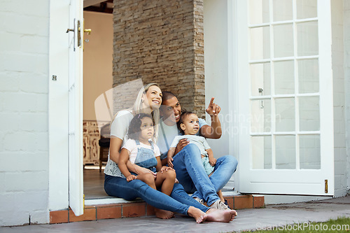 Image of Parents, children and sitting on steps, outdoor and pointing with view, thinking and relax in backyard at family home. Interracial couple, young kids and happy together on patio, veranda and garden