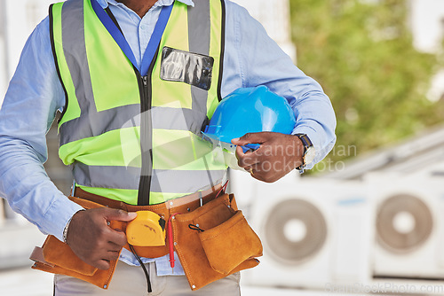 Image of Man, helmet closeup or engineer on construction site for maintenance or architecture outdoor. Body of contractor, professional renovation or handyman building urban infrastructure with tools on waist