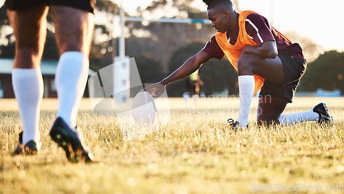 Image of Rugby ball, kick and sport game with holding support, exercise and competition with athlete training. Field, black man and target practice on grass with fitness and team workout outdoor for teamwork