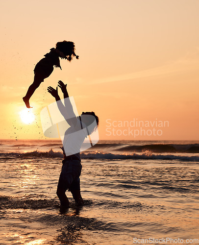 Image of Father, throw and child in air at beach, sunset and waves in the ocean for happiness, fun and support on adventure. Parent, kid and silhouette of dad in the sea with love to play a game with girl