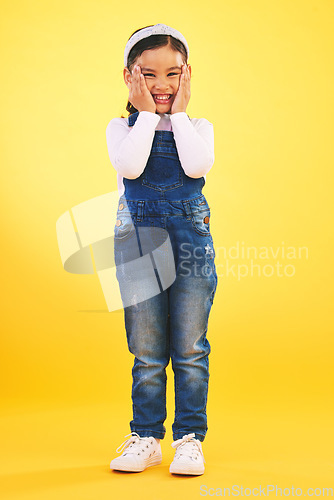 Image of Fashion, portrait and hands on face of girl child in studio with deal, sale or giveaway on yellow background. Wow, emoji and mind blown kid winner with celebration for coming soon, surprise or prize