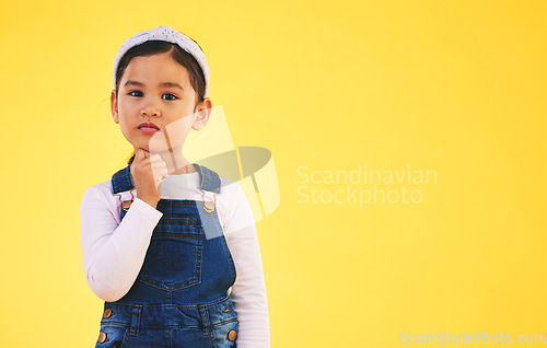 Image of Girl child, studio portrait and space for thinking, promotion or mockup by yellow background. Young female kid, fashion and trendy clothes with hand by face for idea, style or confused with memory