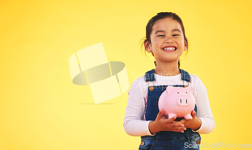 Image of Girl child, piggy bank and saving in studio portrait with smile, mockup space and excited by yellow background. Young female kid, money box and start investment for promo, financial knowledge or goal