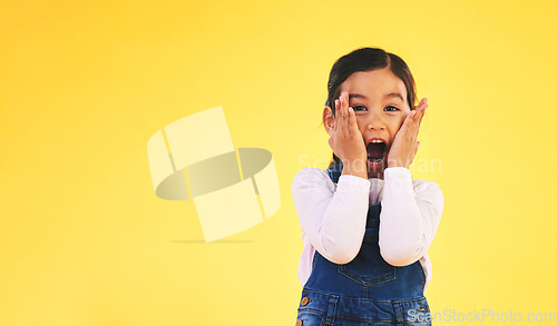 Image of Portrait, fashion and hands on face of girl child in studio with deal, sale or giveaway promo on yellow background. Excited, surprise and open mouth kid with emoji for news, announcement or wow info