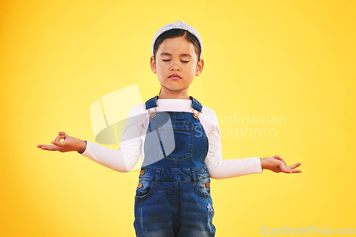 Image of Lotus, hands and girl child with meditation in studio for wellness, peace or balance on yellow background. Children, mental health and kid with yoga pose for energy training or holistic exercise