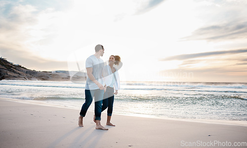 Image of Couple, holding hands and walking on beach at sunset for Portugal holiday, vacation and travel break by nature ocean mockup. Smile, bonding and love for man and woman on sea sand for romantic sunrise