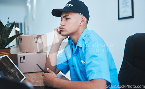 Image of Safety, surveillance and a bored man security guard sitting at a desk in his office to serve and protect. CCTV, control and uniform with a tired officer working as a private government employee