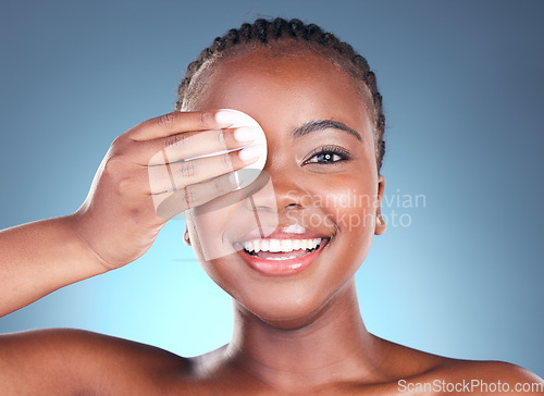 Image of Black woman, portrait smile and cotton pad for makeup removal against a blue studio background. Face of happy African female person with swab in beauty for cleaning, hygiene or facial treatment